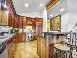 a kitchen with wooden cabinets and a island with bar stools at 502 A Gold Coast! townhouse in Park City