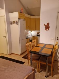 a kitchen with a table and a white refrigerator at Apartment Oulu Varjakka in Oulunsalo