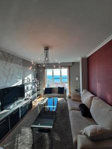 ein Wohnzimmer mit Sofa und Tisch in der Unterkunft Apartamento Las Carolinas in Ribeira