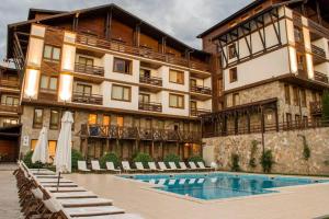 a hotel with a swimming pool in front of a building at Mouse&Mutton Studios in Green Life Ski&Spa Bansko in Bansko