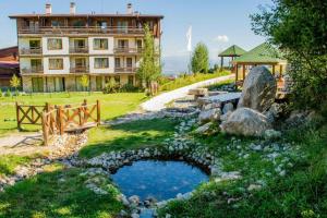 a building and a pond in front of a building at Mouse&Mutton Studios in Green Life Ski&Spa Bansko in Bansko