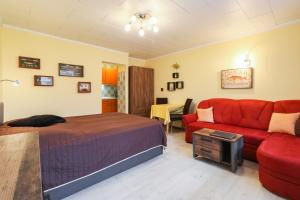 a bedroom with a bed and a red couch at Anke's Inseldomizil in Koserow +15 photos