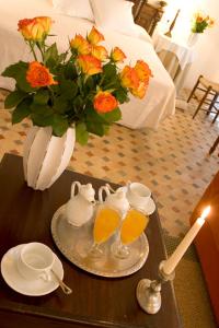 una mesa con dos vasos de zumo de naranja y un jarrón con flores en Turismo de Interior S'Ardeviu en Sóller