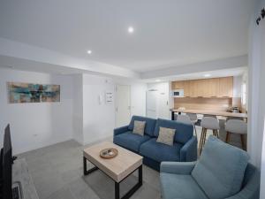 een woonkamer met een blauwe bank en een tafel bij Haus Modern Duque fjHomefj in Jerez de la Frontera