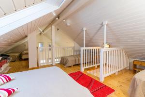 a attic bedroom with two beds and a staircase at Rantakari Cottage in Kotka