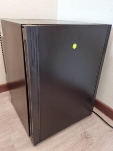 a black refrigerator with a apple on the door at Hotel Westendia in Westende