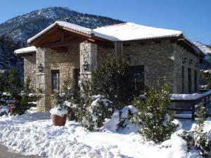 卡拉维塔Georgio's V Chalet Kalavrita的前面有雪的石头房子