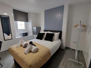 - une chambre avec un grand lit et des serviettes dans l'établissement Stop Stay at The Osterley!, à Swansea