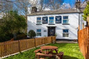 a white house with a picnic table in front of it at Russell Scott Backpackers - Sheffield in Sheffield