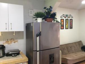 a stainless steel refrigerator in a kitchen with a couch at Casa D' Linda in San Andrés