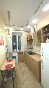 ポルタヴァにあるApartment on Pushkina 23のキッチン(テーブル、白い冷蔵庫付)