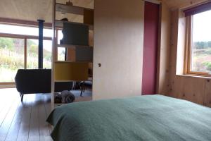 Un dormitorio con una cama y un televisor en una pared. en The Tin Church, en Port na Long