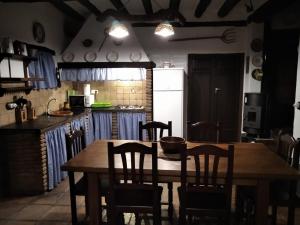 Il comprend une cuisine avec une table et des chaises en bois. dans l'établissement Cortijo La Miel, à Cádiar