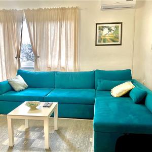 - un canapé bleu dans le salon avec une table dans l'établissement Apartman Sanja, à Banja Luka