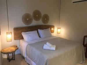 1 dormitorio con 1 cama con 2 toallas en Bangalos do Pontal en Japaratinga