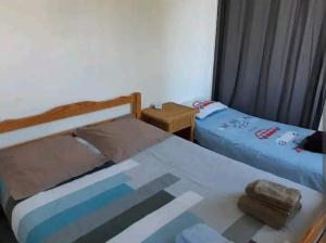 a bedroom with two beds and a glass table at T2 calme, tout confort proche St Emilion/Bordeaux in Les Peintures