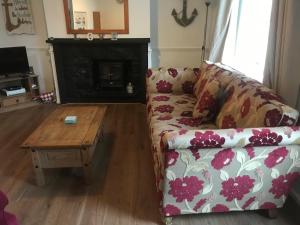 a living room with a couch and a coffee table at Aelfor Cozy Cottage in Barmouth