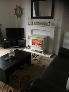 a living room with a fireplace and a tv at Heulwen in Barmouth