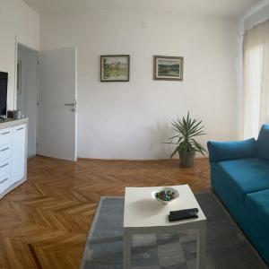 - un salon avec un canapé bleu et une table dans l'établissement Apartman Sanja, à Banja Luka