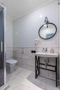 La salle de bains est pourvue d'un lavabo, de toilettes et d'un miroir. dans l'établissement Private House Scherbovets, à Zhdenievo
