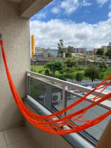 a hammock on a balcony with a view of a city at Jardim Botânico Curitiba in Curitiba