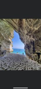 a view of a beach through a rock formation at Stanza per 2 persone da Antonio in Parghelia