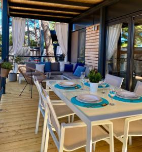 un tavolo bianco e sedie su un patio con divano di Peputo Luxury Residence & Mobile Homes a Rovigno (Rovinj)