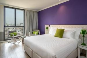 um quarto com uma cama grande e uma parede roxa em Hotel Indigo Tel Aviv - Diamond District, an IHG Hotel em Tel Aviv