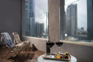 
a table topped with a glass of wine and a plate of food at Hotel Indigo Tel Aviv - Diamond District, an IHG Hotel in Tel Aviv
