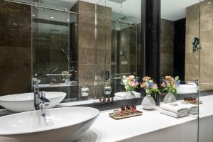 
a bathroom with two sinks and a large mirror at Hotel Indigo Tel Aviv - Diamond District, an IHG Hotel in Tel Aviv
