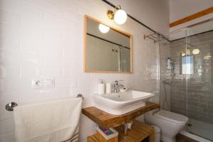 ein Badezimmer mit Waschbecken, Toilette und Spiegel in der Unterkunft Casa Calero in Vezdemarbán
