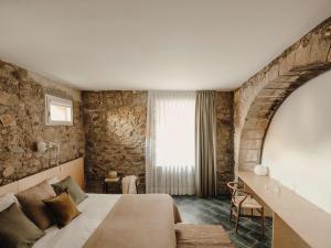 um quarto de hotel com uma cama e uma janela em Paratgea em Llinars del Vallès