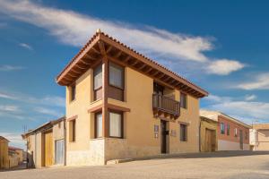 ein gelbes Gebäude mit Balkon darüber in der Unterkunft Casa Calero in Vezdemarbán
