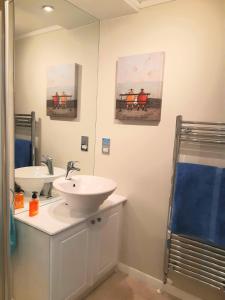 ein Badezimmer mit zwei Waschbecken und zwei Gemälden an der Wand in der Unterkunft Willow Lodge Auchterarder in Auchterarder