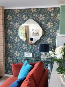 a living room with a red couch and a mirror at Willow Lodge Auchterarder in Auchterarder