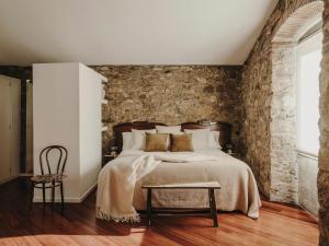 a bedroom with a bed and a brick wall at Paratgea in Llinars del Vallès