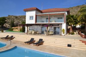 a house with a swimming pool in front of a house at Villa Altavista El Campello, Alicante in El Campello