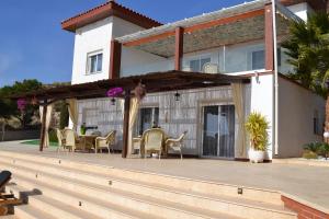 a house with a deck with chairs and a table at Villa Altavista El Campello, Alicante in El Campello