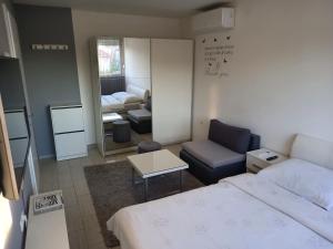 una camera con letto e un soggiorno con divano di Apartment Sven a Vinkovci