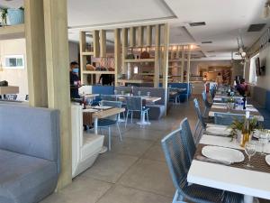 un restaurante con mesas y sillas y gente de fondo en Conforto e Lazer no Golf Ville Resort Alto Padrão en Aquiraz