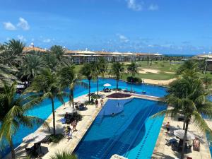 z widokiem na basen z palmami w obiekcie Conforto e Lazer no Golf Ville Resort Alto Padrão w mieście Aquiraz