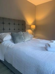 a bedroom with a large bed with white pillows at Column Mews Townhouse in Alnwick