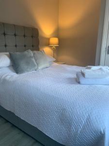 a large white bed with two pillows on it at Column Mews Townhouse in Alnwick