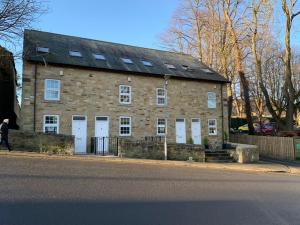 a large brick building with white doors on a street at Column Mews Townhouse in Alnwick