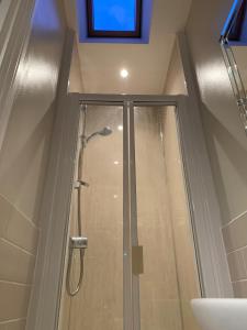 a bathroom with a shower with a glass door at Column Mews Townhouse in Alnwick