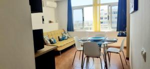 ein Wohnzimmer mit einem Tisch, Stühlen und einem Sofa in der Unterkunft Seven floor at Playa del Ingles in Playa del Ingles