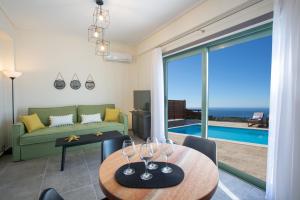 a living room with a couch and a table with wine glasses at Villa Calleste in Kalamitsi