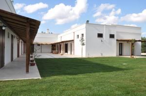 a rendering of a white building with a green lawn at Agriturismo Marconi in Porto Cesareo
