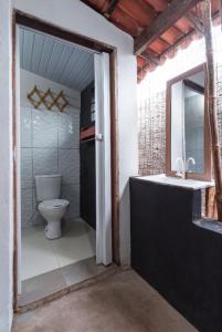 a bathroom with a toilet and a tub and a sink at Canoa Hospedagem in Barra Grande