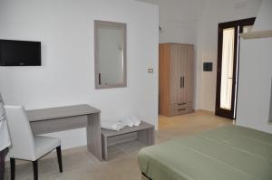 a bedroom with a desk and a table with a chair at Agriturismo Marconi in Porto Cesareo